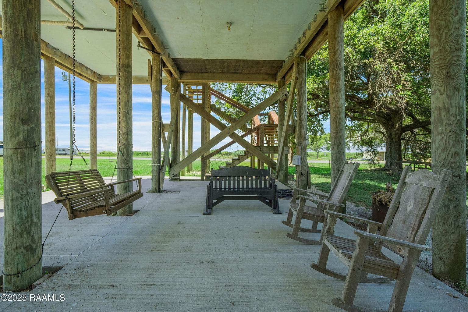 Porch swings in the shaded space beneath the camp